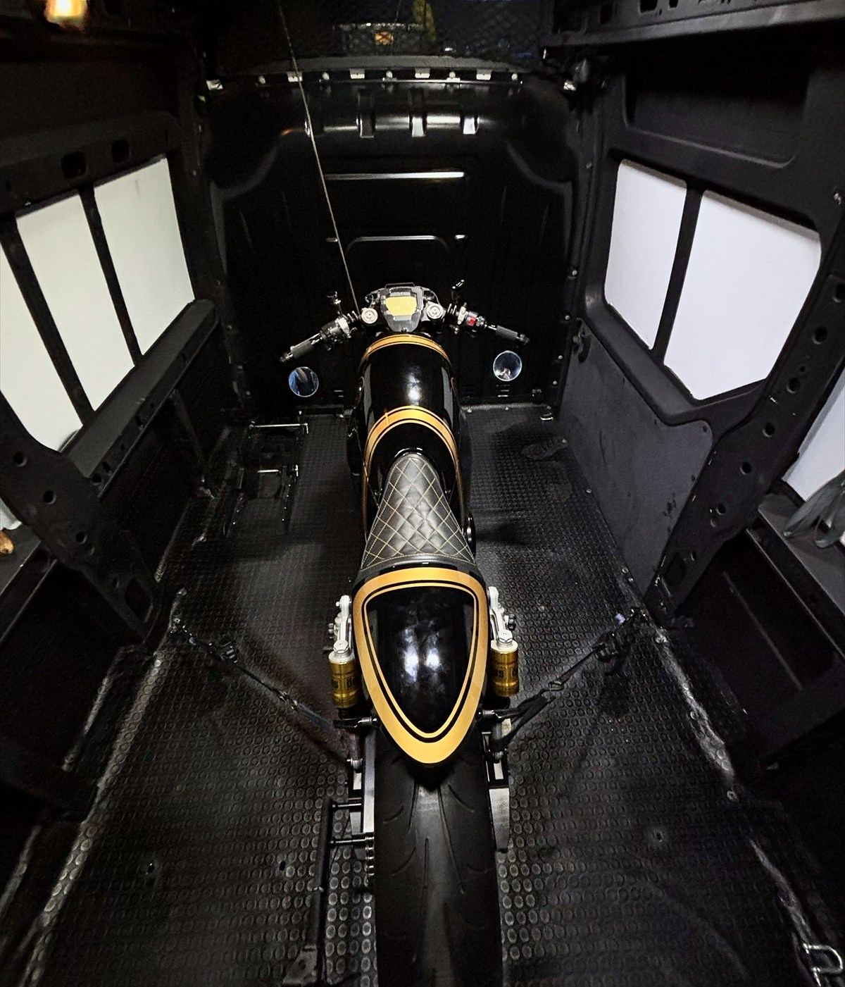 A motorcycle in its secure, dedicated place inside the MC Station van